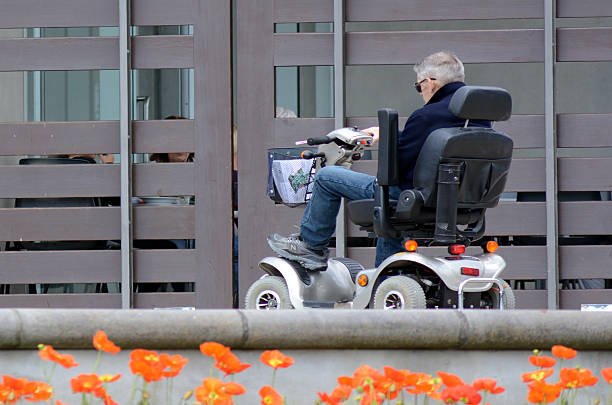 Senior couple enjoying outdoor independence with a premium mobility scooter by the UK seaside